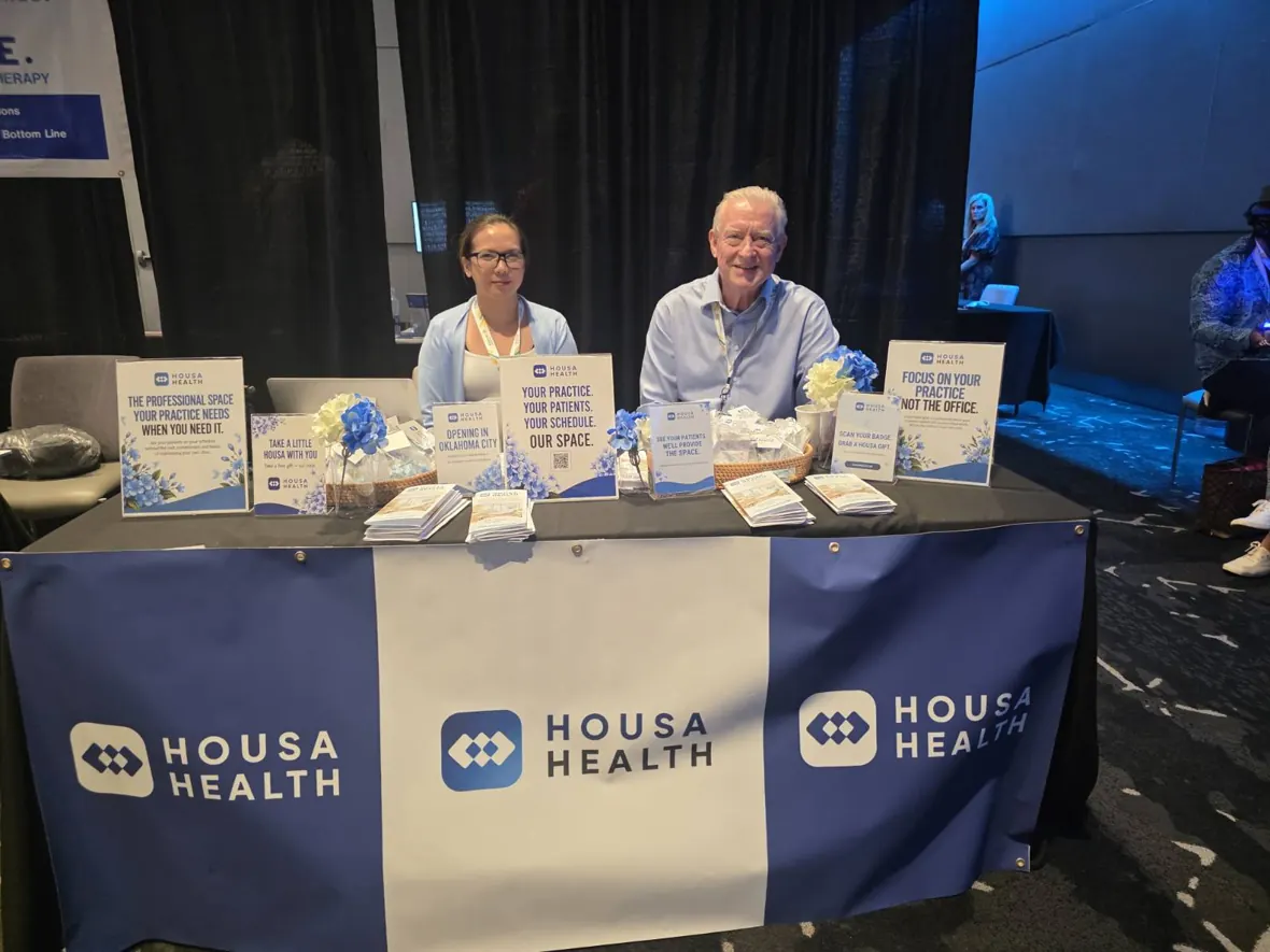 Housa Health exhibition table with branded signage and representatives